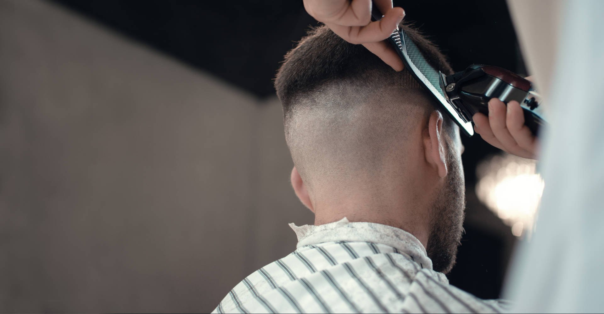 Profissional fazendo corte em cabelo de modelo branco